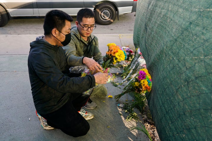 Two men place flowers near Star Dance Studio to honor victims killed in a shooting in Monterey Park, Calif., on Jan. 22, 2023. 