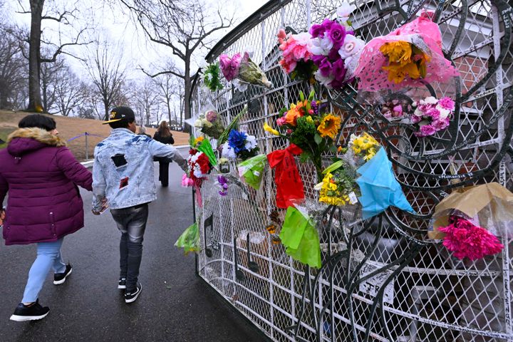 Μπουκέτα με λουλούδια στην περίφραξη της έπαυλης (AP Photo/John Amis)