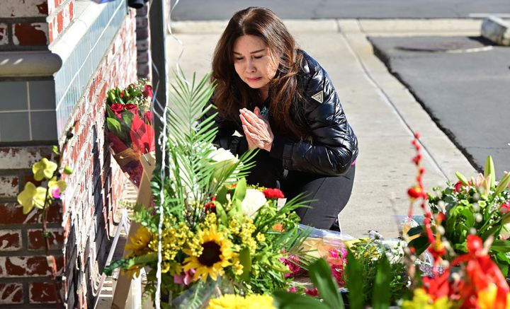 A woman who lost several friends at the Monterey Park shooting grieves at a makeshift memorial outside the Star Dance Studio in the Los Angeles suburb.