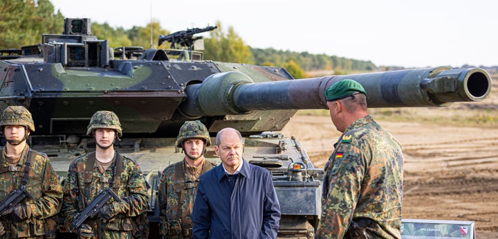 German Chancellor Olaf Scholz stands with German army Bundeswehr soldiers at a "Leopard 2" main battle tank during a training and instruction exercise in in Ostenholz, Germany, on Oct. 17, 2022. Scholz announced Wednesday, Jan. 25, 2023, that his government will approve supplying German-made battle tanks to Ukraine.