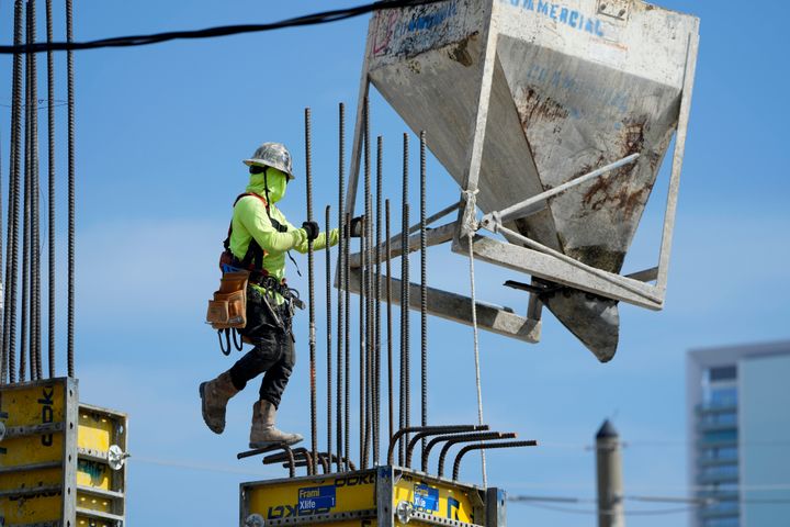 A worker guides a bin into position at a construction site, Tuesday, Jan. 24, 2023, in Miami. The Commerce Department issues its first of three estimates of how the U.S. economy performed in the fourth quarter of 2022. On Thursday, the Commerce Department issues its first of three estimates of how the U.S. economy performed in the fourth quarter of 2022.(AP Photo/Lynne Sladky)