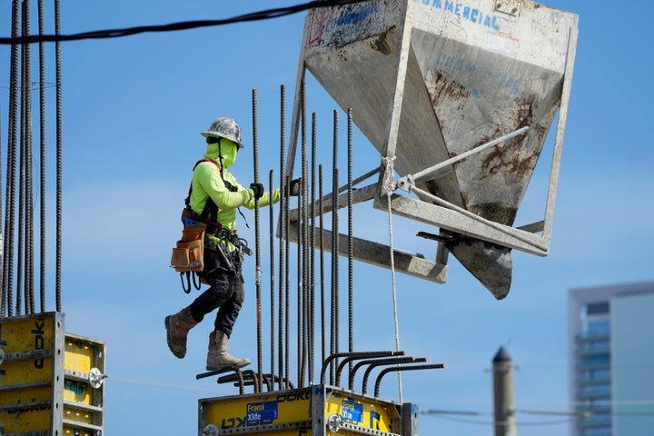 A worker guides a bin into position at a construction site, Tuesday, Jan. 24, 2023, in Miami. The Commerce Department issues its first of three estimates of how the U.S. economy performed in the fourth quarter of 2022. On Thursday, the Commerce Department issues its first of three estimates of how the U.S. economy performed in the fourth quarter of 2022.(AP Photo/Lynne Sladky)