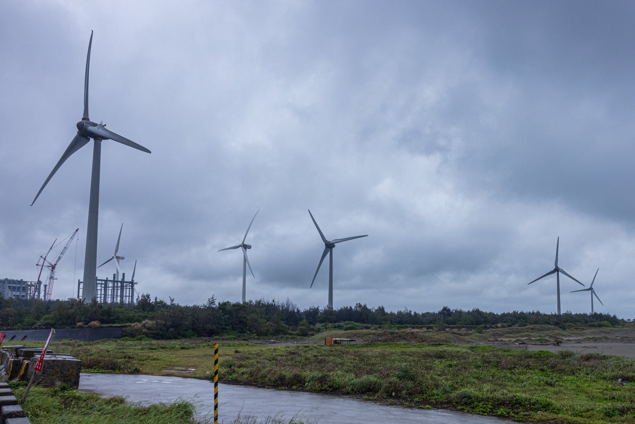 Wind turbines dot the land near a construction site for new gas infrastructure in Taoyuan, Taiwan.