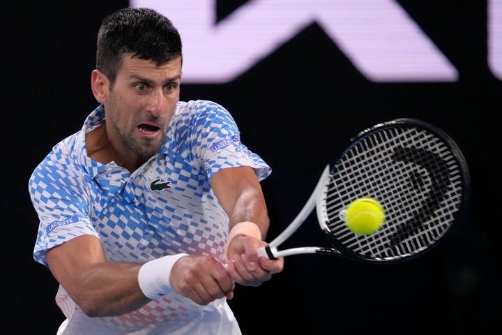 Novak Djokovic of Serbia plays a backhand return to Stefanos Tsitsipas of Greece during the men's singles final at the Australian Open tennis championship in Melbourne, Australia, Sunday, Jan. 29, 2023. (AP Photo/Dita Alangkara)