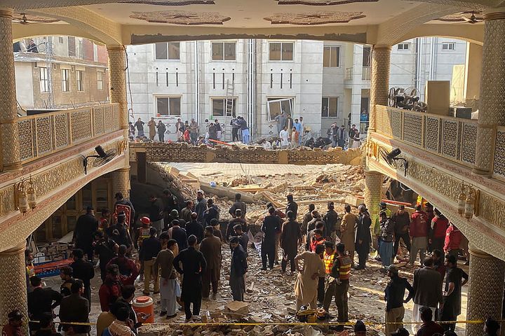 Security officials inspect the site of a mosque blast inside the police headquarters in Peshawar on Jan. 30, 2023.