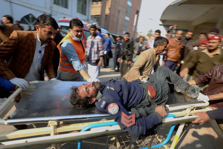 Workers and volunteers carry an injured victim of a suicide bombing upon arrival at a hospital in Peshawar, Pakistan, Monday, Jan. 30, 2023.