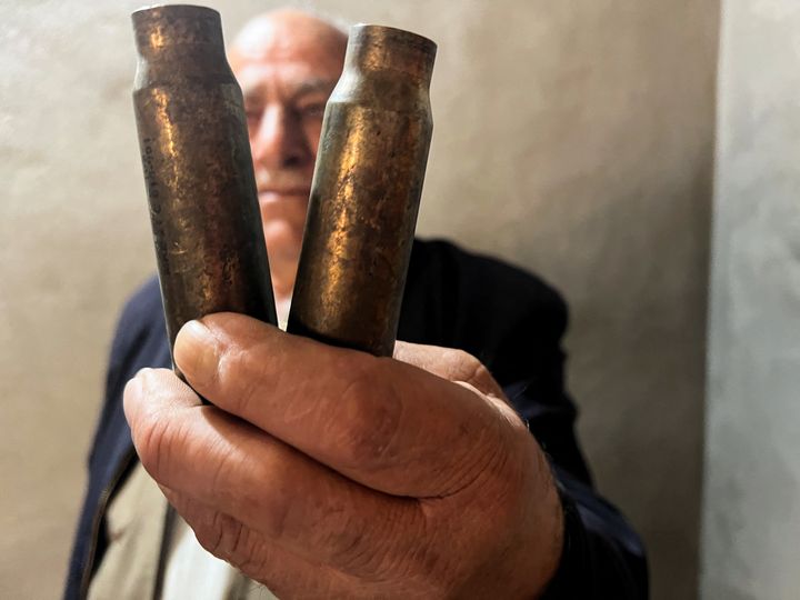 Ο Χαϊντέρ Μοχάμεντ Χαλέντ κρατά κάλυκες που είπε ότι βρήκε στο σπίτι του στο χωριό Σαράρο, μετά τους τουρκικούς βομβαρδισμούς την περασμένη άνοιξη στην περιοχή,