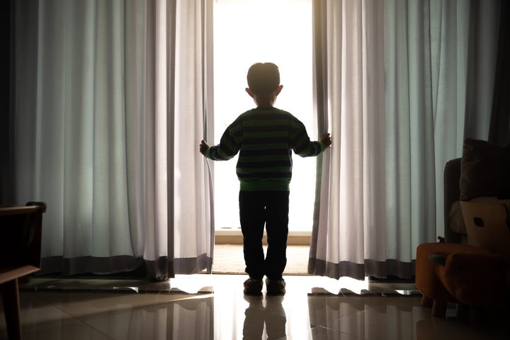 Boy opening curtain