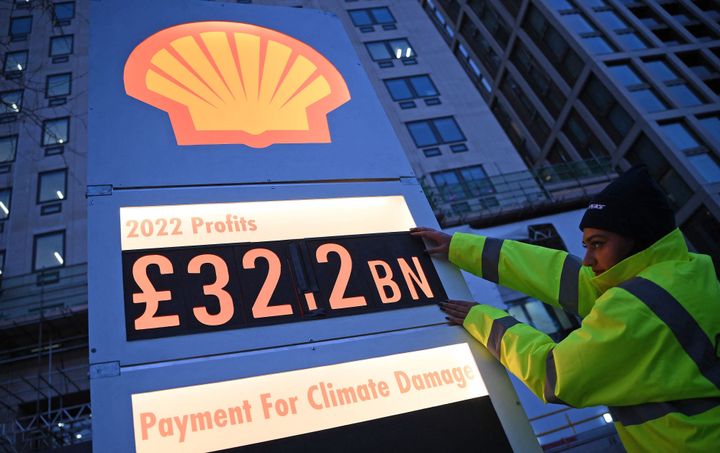 Activists from Greenpeace set up a mock-petrol station price board displaying the company's net profit for 2022