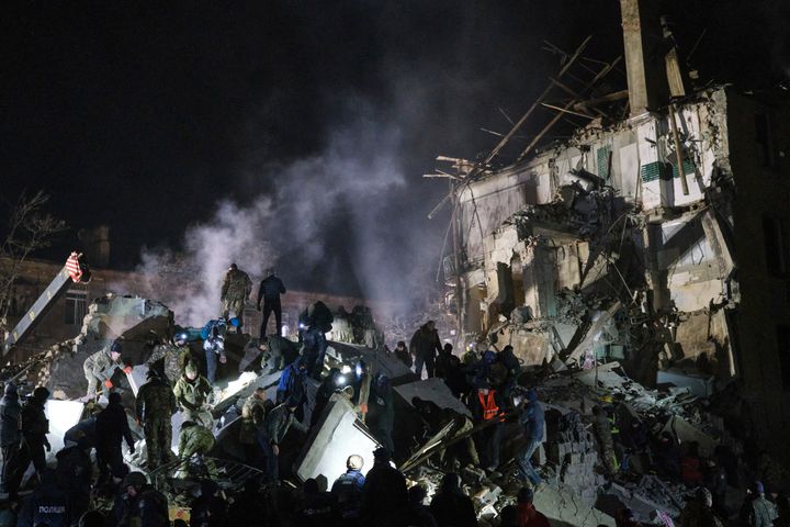 Emergency workers and local residents clear the rubble after a Russian rocket hit an apartment building in Kramatorsk, Ukraine, on Feb. 2, 2023. 