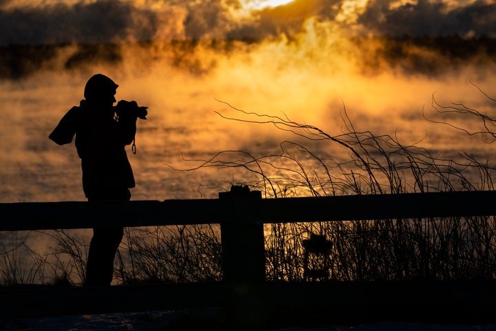 Kim Hunt of Cumberland, Maine, photographs arctic sea smoke on the coast of South Portland, Maine, Saturday, Feb. 4, 2023.