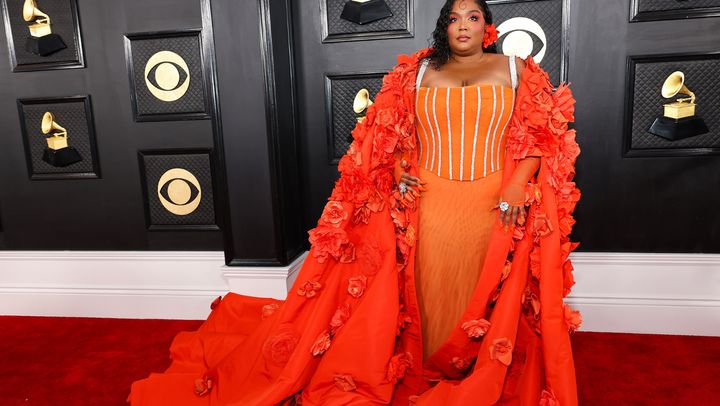 Lizzo sporting a Dolce & Gabanna gown during the 65th Grammys Awards, accented with floral appliqués.