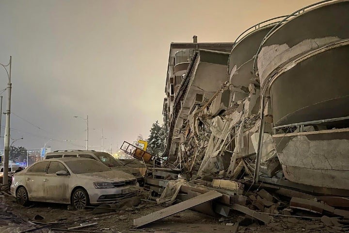 Damaged vehicles sit parked in front of a collapsed building following an earthquake in Diyarbakir, southeastern Turkey.