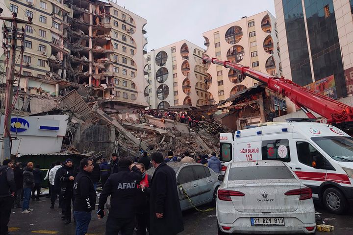Rescue workers and medical teams try to reach trapped residents in a collapsed building following an earthquake in Diyarbakir, southeastern Turkey, early Monday, Feb. 6, 2023. 