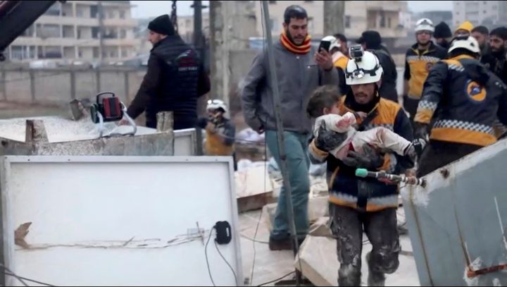 A rescuer carries an injured child away from the rubble of a building following an earthquake in rebel-held Azaz, Syria February 6, 2023 in this still image taken from video. REUTERS/via Reuters TV