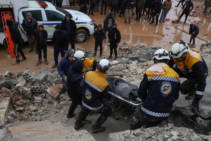 Members of the Syrian civil defence, known as the White Helmets transport a casualty pulled from the rubble following an earthquake in the town of Zardana in the countryside of the northwestern Syrian Idlib province, early on Feb. 6, 2023.