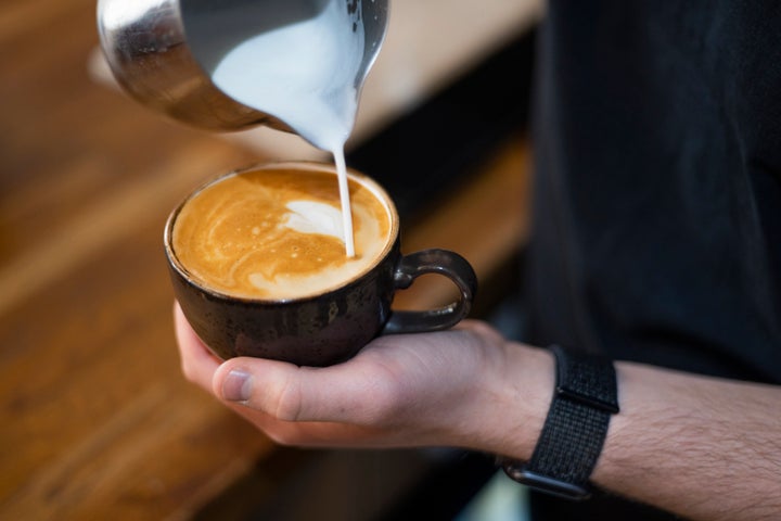 Kοντινή λήψη άγνωστου barista που φτιάχνει ένα φρέσκο φλιτζάνι καφέ.