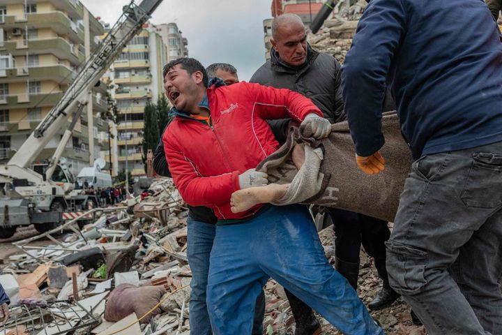 瓦礫の中から見つかった遺体を運ぶ救助隊員（トルコ・アダナ）