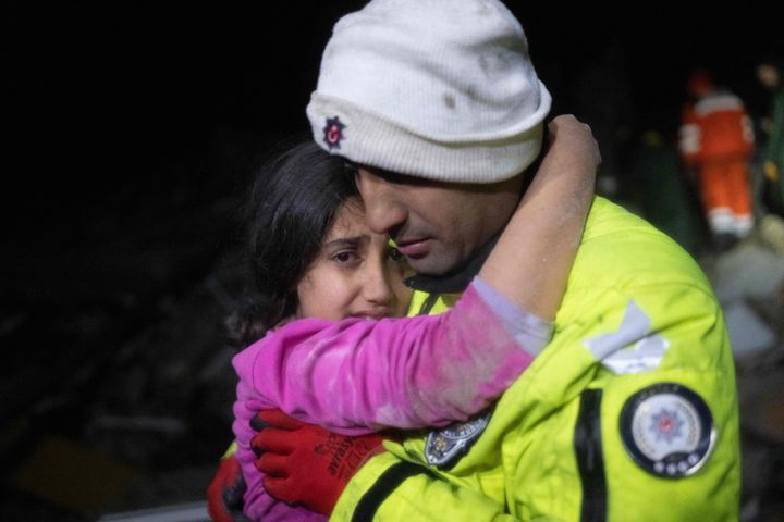 トルコ南部ハタイ県で、地震後にがれきの中から救出された少女を抱き上げる父親