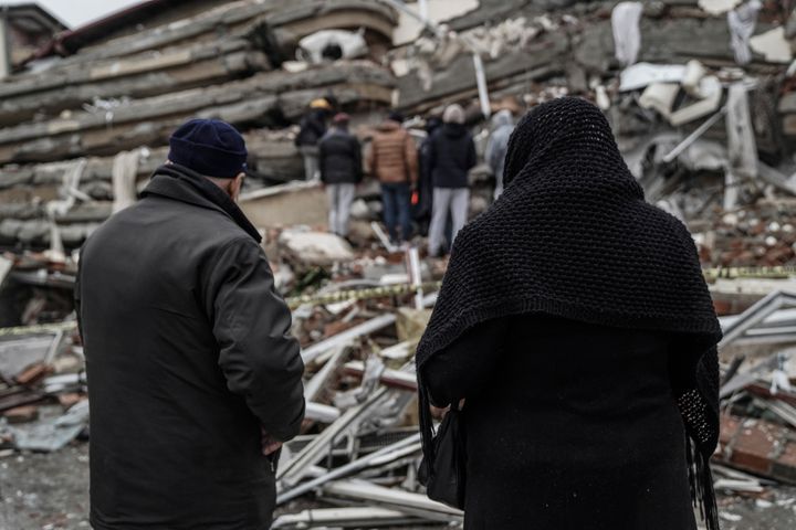 People and emergency teams search for people in the rubble in a destroyed building in Gaziantep, Turkey, on Feb. 6, 2023. 