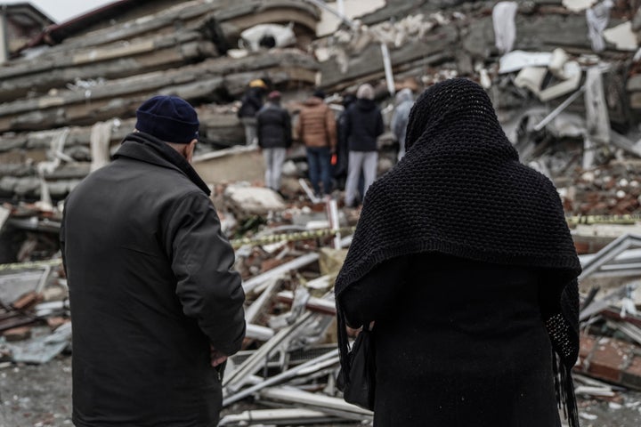People and emergency teams search for people in the rubble in a destroyed building in Gaziantep, Turkey, on Feb. 6, 2023.