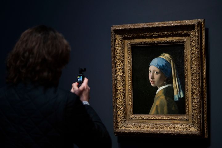 Δημοσιογράφος φωτογραφίζει το διάσημο έργο του Βερμέερ «Το Κορίτσι Με το Μαργαριταρένιο Σκουλαρίκι» στο Rijksmuseum του Άμστερνταμ, Δευτέρα, 6 Φεβρουαρίου 2023. (AP Photo/Peter Dejong)