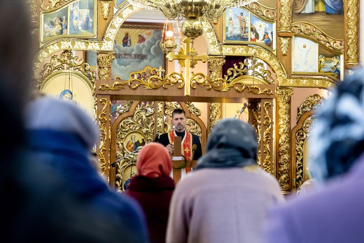 Ουκρανοί πιστοί παρευρίσκονται στη λειτουργία της Μεγάλης Παρασκευής στην Ελληνο-Καθολική εκκλησία στο Ναντίμπι στην περιφέρεια του Λβιβ, Ουκρανία στις 22 Απριλίου 2022. Καθώς η Ρωσική Ομοσπονδία εισέβαλε στην Ουκρανία, η σύγκρουση ανάγκασε περισσότερους από 10 εκατομμύρια Ουκρανούς να εγκαταλείψουν τις εμπόλεμες ζώνες, και να μετατωπιστούν εσωτερικά και εξωτερικά. Η περιφέρεια του Λβιβ φιλοξενεί πολλούς από τους εσωτερικούς πρόσφυγες. Το χωριό Nαντίμπι και η ελληνορθόδοξη εκκλησία του έγιναν καταφύγιο για δεκάδες πρόσφυγες από το Χάρκοβο, το Ντονέτσκ και τη Ζαπορίζια. Καθώς οι Ουκρανοί πιστοί συγκεντρώνονται για τους ορθόδοξους εορτασμούς του Πάσχα, οι ντόπιοι χριστιανοί και οι πρόσφυγες γιορτάζουν μαζί το Πάσχα.