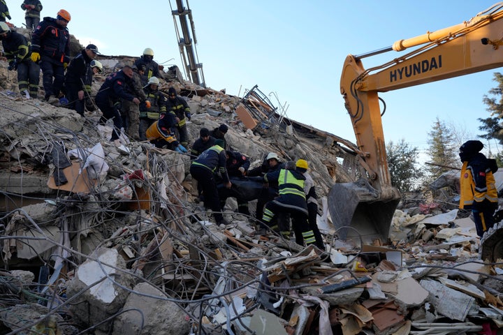 Firefighters carry a dead body from a destroyed building, in Gaziantep, southeastern Turkey, on Feb. 8 , 2023.