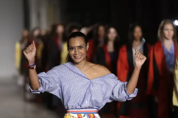 Designer Stella Jean accepts applause at the end of her women's Spring/Summer 2018/19 fashion collection, presented in Milan, Italy, on Sept. 24, 2017. 