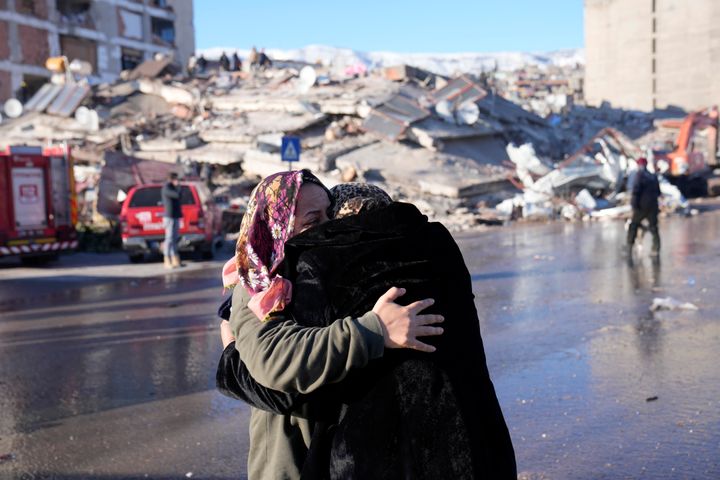 Two women hug each other in front of a destroyed building in Kahramanmaras, southern Turkey, on Feb. 8, 2023. 