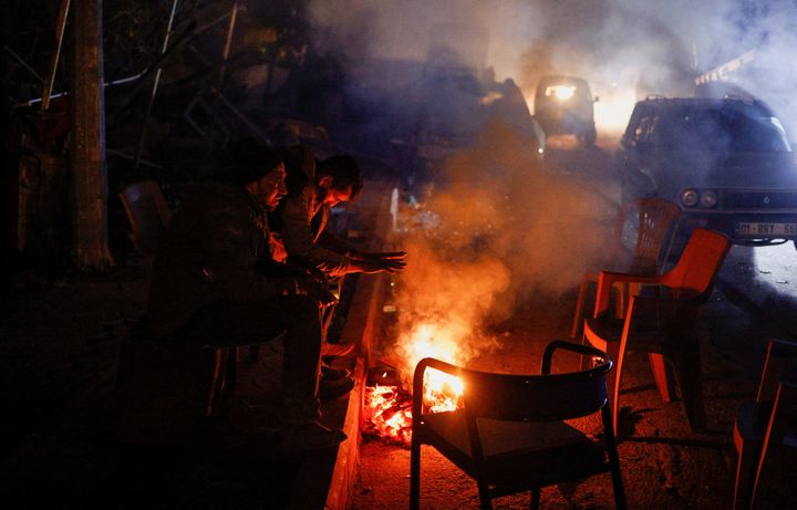 Οι άνθρωποι ζεσταίνονται γύρω από μια φωτιά μετά από έναν σεισμό στην Αντάκια.