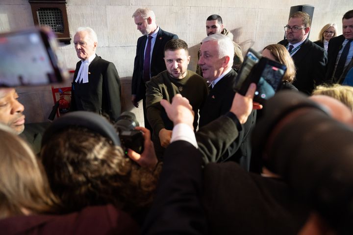 Zelenskyy shakes hands with MPs as he walks with Speaker of the House of Commons, Sir Lindsay Hoyle, and Speaker of the House of Lords, Lord McFall