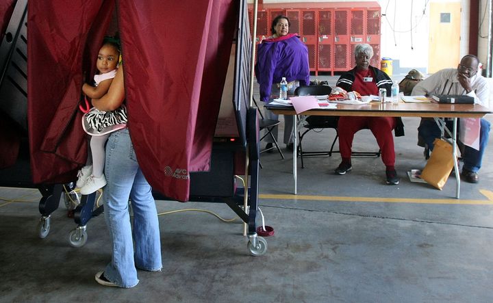 Ashley Moore holds her daughter Madison while casting her ballot in the presidential primary on Feb. 9, 2008, in New Orleans just three years after Hurricane Katrina devastated the city.