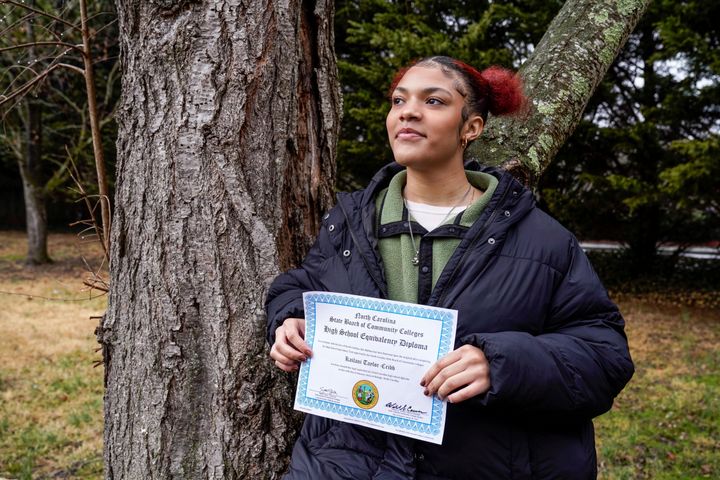 Kailani Taylor-Cribb holds her GED diploma outside her home in Asheville, N.C., on Jan. 31, 2023. 
