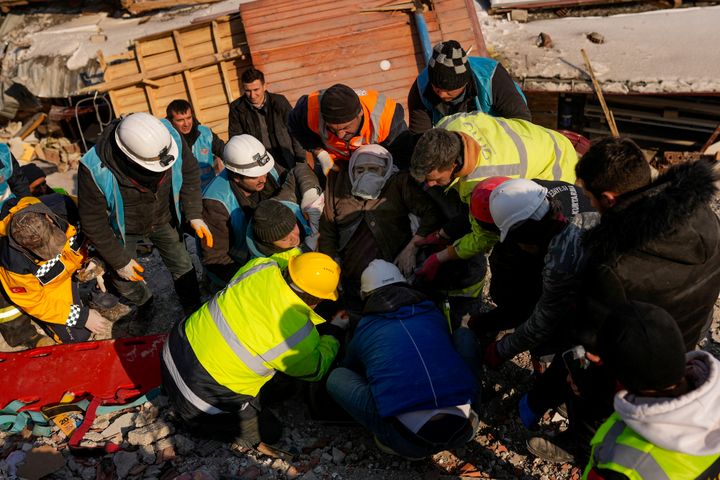 Turkish woman Hatice Korkut, center, 82, is rescued alive by rescue team members from a destroyed building in Elbistan, southeastern Turkey, Thursday, Feb. 9, 2023. Tens of thousands of people who lost their homes in a catastrophic earthquake huddled around campfires in the bitter cold and clamored for food and water Thursday, three days after the temblor hit Turkey and Syria. (AP Photo/Francisco Seco)
