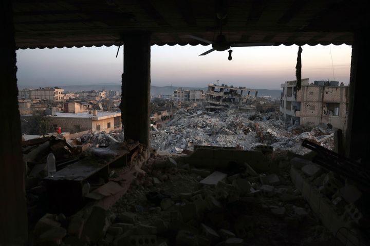 Collapsed buildings are seen through the windows of a damaged house following a devastating earthquake in the town of Jinderis, Aleppo province, Syria, Thursday, Feb. 9, 2023. The quake that razed thousands of buildings was one of the deadliest worldwide in more than a decade. . (AP Photo/Ghaith Alsayed)