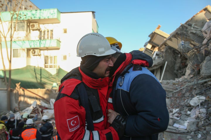 Rescuers weep by a collapsed building in Adiyaman, southern Turkey, on Feb. 9, 2023.