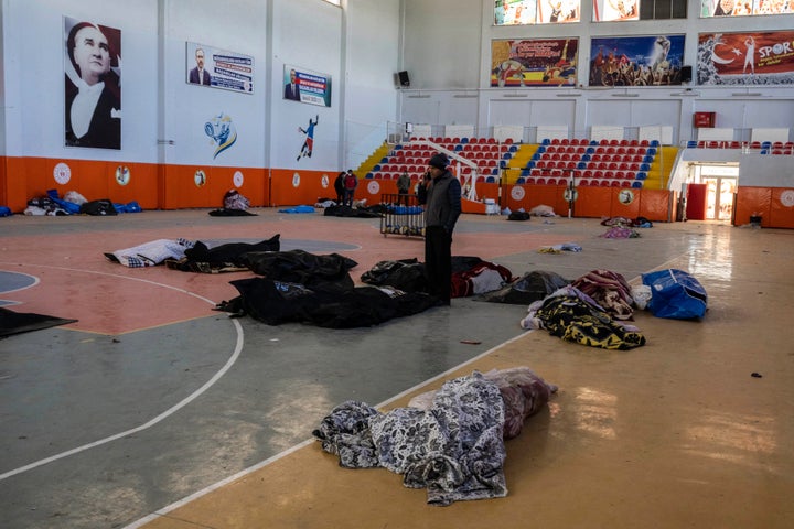 A man speaks on his cellphone among bodies, victims of the earthquake, at an indoor stadium, in Kahramanmaras, southeastern Turkey, on Feb. 9, 2023.