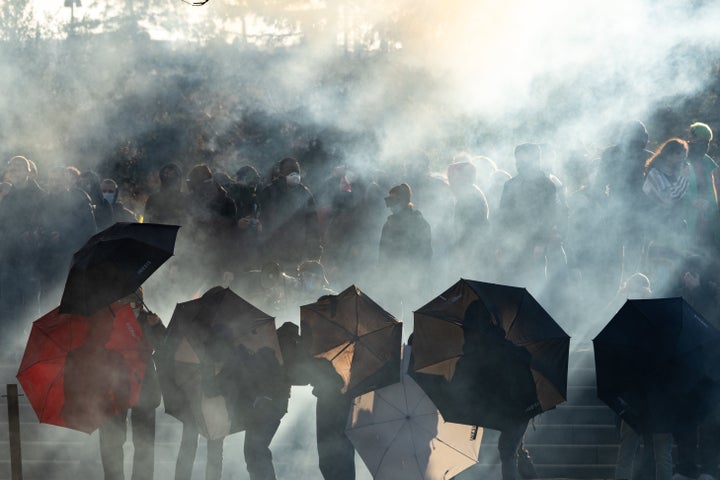 Protesters holding umbrellas clashed with police who used a lot of tear gas.