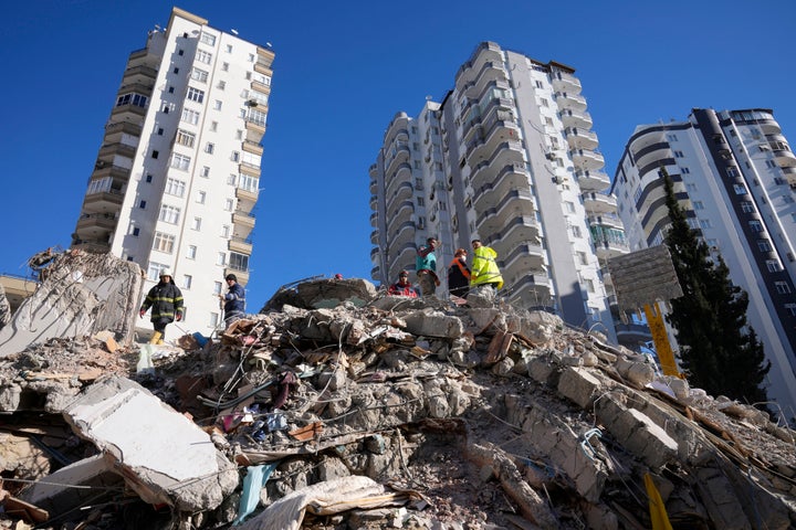 FILE - Emergency teams search for people in the rubble of a destroyed building in Adana, southern Turkey, Tuesday, Feb. 7, 2023. For Syrians and Ukrainians fleeing the violence back home, the earthquake that struck in Turkey and Syria is but the latest tragedy. The U.N. says Turkey hosts about 3.6 million Syrians who fled their country’s 12-year civil war, along with close to 320,000 people escaping hardships from other countries. (AP Photo/Hussein Malla, File)