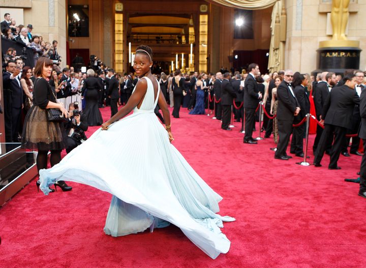 Lupita Nyong'o walks the red carpet at the 2014 Oscars in a stunning Prada gown.
