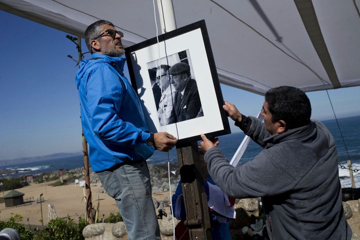 Workers place a portrait of Neruda with former President Salvador Allende at Neruda's tomb in 2016 after he was reburied on Isla Negra, Chile. Forensic experts were expected to report on his causes of death. 
