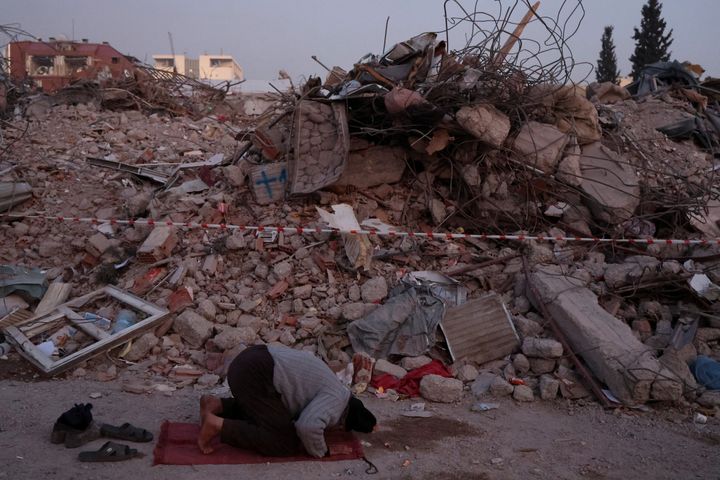 Ένας άνδρας προσεύχεται κοντά στα ερείπια κατεστραμμένων σπιτιών, στον απόηχο ενός θανατηφόρου σεισμού στο Καχραμανμάρας, Τουρκία, 14 Φεβρουαρίου 2023.
