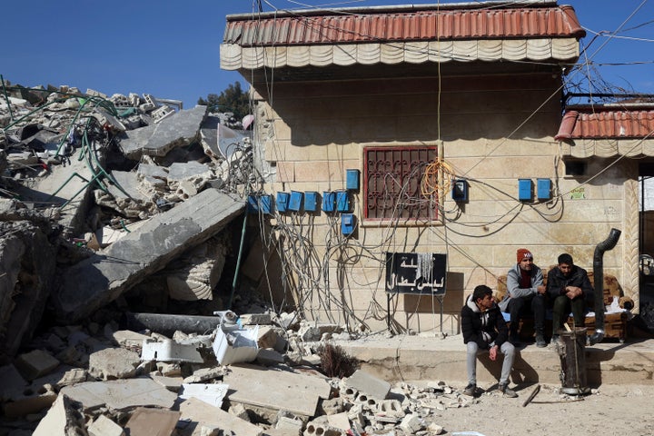 People remove their furniture and household appliances out of a collapsed building following a devastating earthquake in the town of Jinderis, Aleppo province, Syria, Tuesday, Feb. 14, 2023. The death toll from the earthquakes of Feb. 6, that struck Turkey and northern Syria is still climbing. (AP Photo/Ghaith Alsayed)