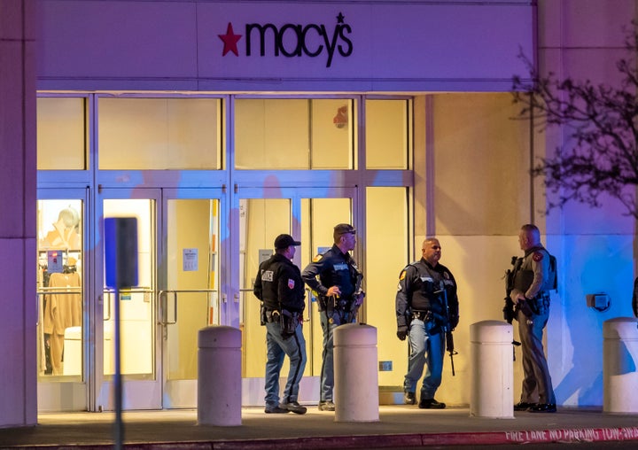 Police officers stand guard at an entrance of a shopping mall on Wednesday in El Paso, Texas. Police said a second person has been taken into custody following a shooting at the mall.