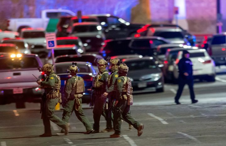 Law enforcement agents walk in the parking lot of a shopping mall on Wednesday in El Paso, Texas. Police say one person was killed and three other people were wounded in a shooting at Cielo Vista Mall.
