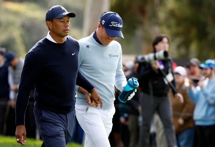 Tiger Woods hands the tampon to Justin Thomas.