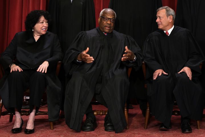 Supreme Court Associate Justices Sonia Sotomayor and Clarence Thomas pose with Chief Justice John Roberts for an official portrait on Oct. 7 in Washington.