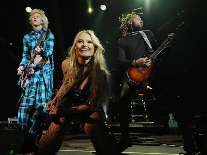 Machine Gun Kelly and guitarists Sophie Lloyd and Justin Lyons perform during the 2023 Sports Illustrated Super Bowl party on Feb. 11, 2023, in Scottsdale, Arizona.