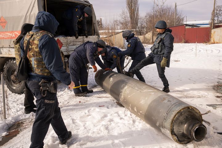 Ukrainian emergency services employees prepare to load the remains of an S-300 missile fired by Russian forces onto a truck in Kharkiv, Ukraine, Friday, Feb. 17, 2023. Russia pummeled Ukraine with a barrage of cruise and other missiles on Thursday, hitting targets from east to west as the war's one-year anniversary nears, one of the strikes killed a 79-year-old woman and injured at least seven other people, Ukrainian authorities said. (AP Photo/Vadim Ghirda)
